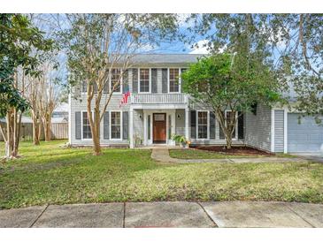 Two-story house with gray siding, landscaping, and a walkway at 1718 Errol Woods Dr, Apopka, FL 32712