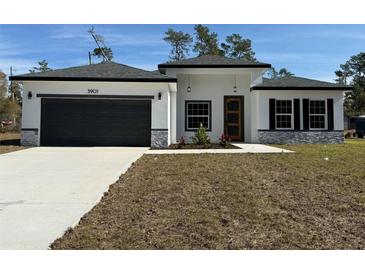 New construction home with gray garage door and stone accents at 3901 Sw 161St Loop, Ocala, FL 34473