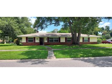 Charming single-story home featuring a brick facade, red shutters, and a well-maintained front lawn at 4131 Yorketowne Rd, Orlando, FL 32812