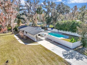 Aerial view of the home with a large pool, fenced in yard, and mature landscaping at 520 Sw 38Th St, Ocala, FL 34471