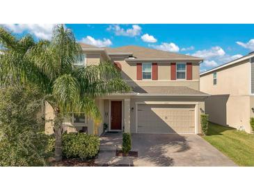 Two-story house with tan siding, brown door, and a two-car garage at 5317 Jubiloso Dr, St Cloud, FL 34771