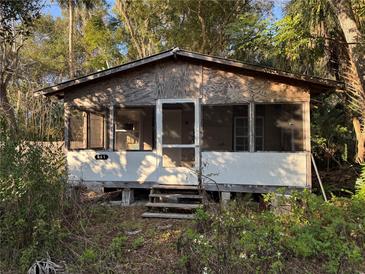 Rustic wood home with screened porch, needing renovation, surrounded by trees at 641 W Beresford Rd, Deland, FL 32720