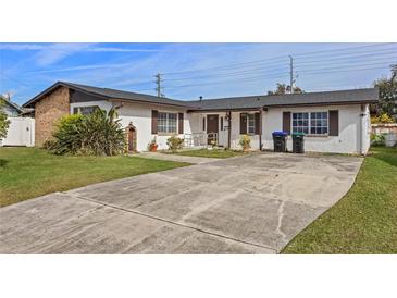 Ranch-style home with a large driveway and mature landscaping at 6517 Precourt Dr, Orlando, FL 32809