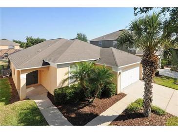 Single-story house with a gray roof, light-orange walls, and a two-car garage at 8515 Sunrise Key Dr, Kissimmee, FL 34747