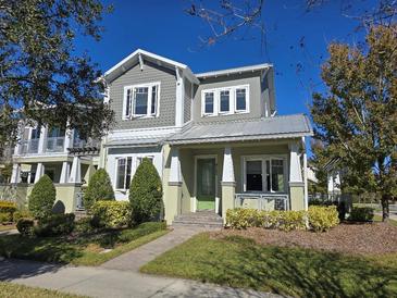 Two-story craftsman style home with green exterior and metal roof at 9121 Laureate Blvd, Orlando, FL 32827