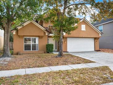 Two-story house with attached garage, landscaping, and a tan exterior at 942 Beresford Way, Lake Mary, FL 32746