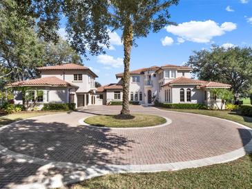 Luxury home with circular driveway, tile roof, and mature landscaping at 9512 Tavistock Rd, Orlando, FL 32827