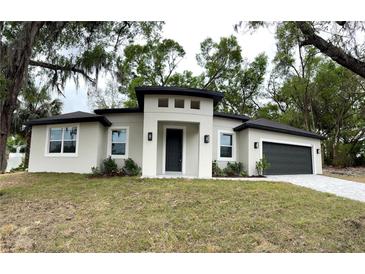Charming single-story home with a modern design, fresh landscaping, and a two-car garage at 116 E Cleveland St, Apopka, FL 32703