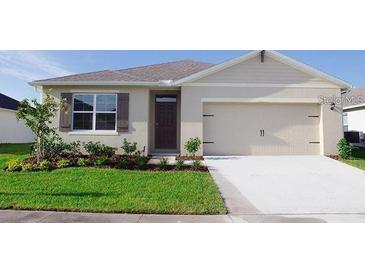 One-story home with two-car garage and landscaped lawn at 1542 Wax Myrtle Way, Haines City, FL 33844