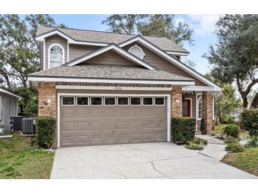 Two-story house with a brown exterior, brick accents, and a two-car garage at 2705 Grantham Ct, Orlando, FL 32835