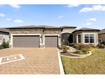 Two-story home with stone accents and three-car garage at 5599 Sw 92Nd Avenue Rd, Ocala, FL 34481
