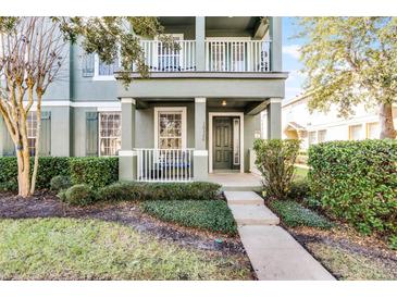 Two-story house with green exterior, balcony, and landscaped yard at 10326 Lake District Ln # 30, Orlando, FL 32832