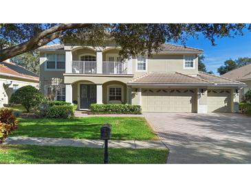 Two-story house with a three-car garage and manicured lawn at 346 Calliope St, Ocoee, FL 34761