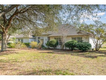Charming single-story home with mature trees, manicured shrubs, and a well maintained lawn at 36502 Barrington Dr, Eustis, FL 32736