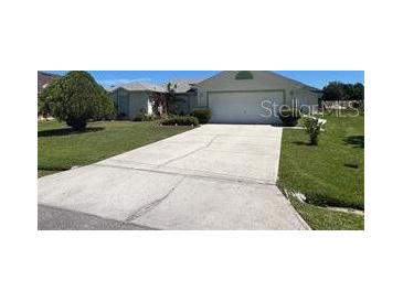 Single-story house with driveway and landscaped yard at 517 Cardinal Dr, Kissimmee, FL 34759