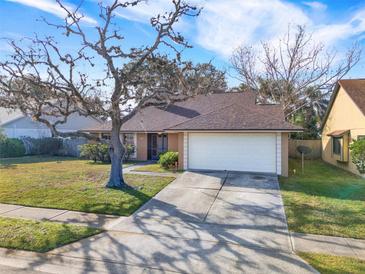 Single-story house with a brown roof, attached garage, and mature landscaping at 626 Brookfield Loop, Lake Mary, FL 32746
