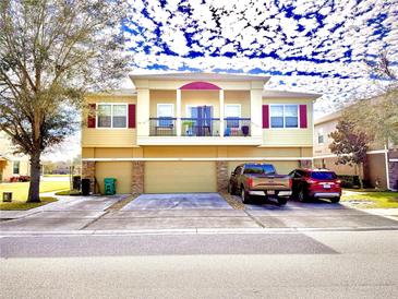 Tan three-story townhome with two-car garage and balcony at 1604 Scarlet Oak Loop # B, Winter Garden, FL 34787