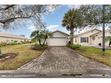 House exterior showcasing a paved driveway, landscaping, and a two-car garage at 212 Rialto Rd, Kissimmee, FL 34759