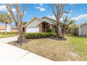 House exterior with a two car garage and landscaping at 3131 Ash Park Loop, Winter Park, FL 32792