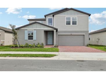 Charming two-story home with a brick driveway, a gray exterior, and a light blue front door at 3801 Giorgio Dr, Winter Haven, FL 33884