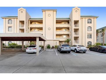 A multi-story building with assigned parking, featuring a well-maintained exterior with a green roof and tan facade at 432 Bouchelle Dr # 102, New Smyrna Beach, FL 32169