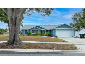 Light blue house with a white garage door and mature landscaping at 5535 Long Lake Dr, Orlando, FL 32810