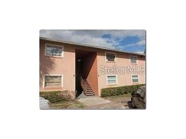 Tan colored two-story building with stairs leading to the entrance at 5885 Dahlia Dr # 24, Orlando, FL 32807