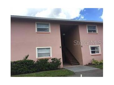 Light pink two-story building with stairs and landscaping at 5885 Dahlia Dr # 29, Orlando, FL 32807