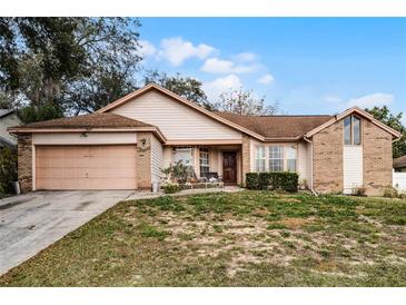 One-story house with attached garage and manicured lawn at 7025 Hiawassee Oak Dr, Orlando, FL 32818