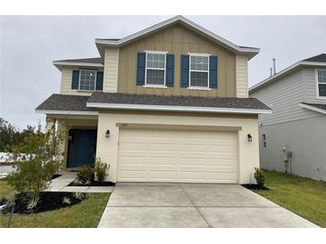 Two-story house with a neutral color scheme and a large garage at 1012 Anchorage Street, Leesburg, FL 34748