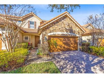 Inviting stone and stucco home with a 2-car garage and well-manicured landscaping at 10329 Belfry Cir, Orlando, FL 32832