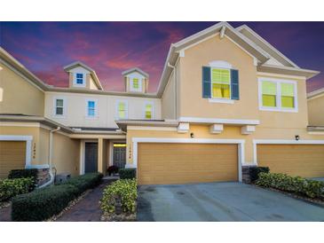 Two-story townhome with a two-car garage and landscaped walkway at 17454 Chateau Pine Way, Clermont, FL 34711