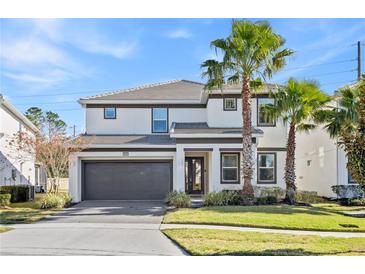 Two-story house with gray accents, a two-car garage, and palm trees at 2639 Calistoga Ave, Kissimmee, FL 34741
