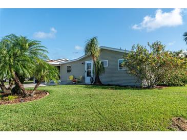 Charming ranch home with a well-manicured lawn and tropical landscaping at 26608 Bermuda Dr, Tavares, FL 32778