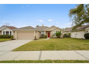 One-story house with a red door, attached garage, and well-maintained lawn at 2984 Cedar Glen Pl, Oviedo, FL 32765