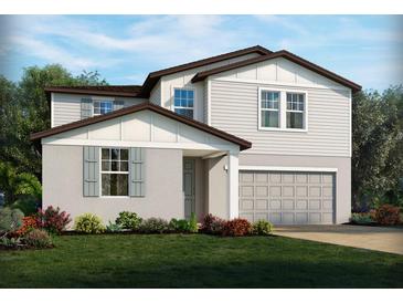 Two-story house with gray siding, brown accents, and a two-car garage at 3257 Viceroy Ct, Poinciana, FL 34759