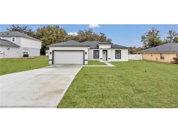 Modern one-story house with gray roof, white walls, and a two-car garage at 3999 Sw 129Th St, Ocala, FL 34473