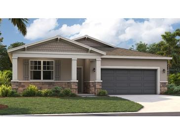 One-story home with gray siding, stone accents, and a two-car garage at 879 Pebble Crest Ln, Eagle Lake, FL 33839