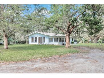 White single story home with large trees and a spacious yard at 11431 Nw 100Th St, Ocala, FL 34482