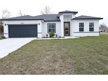 One-story house with gray roof, white walls, and a dark gray garage door at 14511 Sw 29Th Ter, Ocala, FL 34473