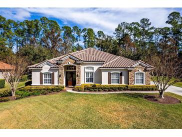 Single-story home with tile roof, stone accents, and lush landscaping at 1458 Foxtail Dr, Lake Mary, FL 32746