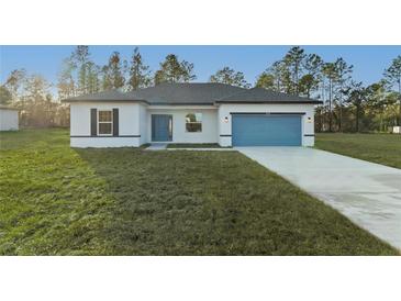 Inviting single-story home featuring a well-manicured lawn, blue accents and an attached two car garage at 1719 Sw 166Th St, Ocala, FL 34473