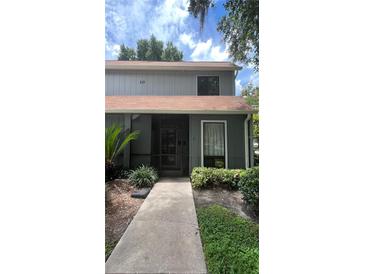 Charming two-story home with landscaped front yard and inviting walkway to the front door at 10 Moree Loop # 1, Winter Springs, FL 32708