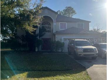 Two-story house with attached garage and landscaping at 1010 Embrun Ct, Kissimmee, FL 34759