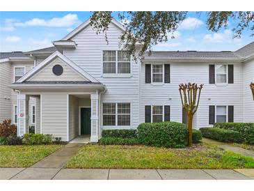 Two story townhome with light beige siding and dark green door at 130 Southern Pecan Cir # 102, Winter Garden, FL 34787