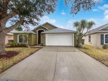 House exterior features a two-car garage and a well-maintained lawn at 142 Brushcreek Dr, Sanford, FL 32771