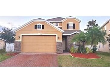 Two-story house with a large garage and well-manicured lawn at 14324 Fieldstone Lake Way, Orlando, FL 32824