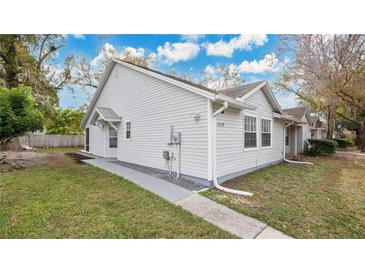 White vinyl-sided house with a red front door and landscaped yard at 1659 Rivers Edge Dr, Orlando, FL 32825