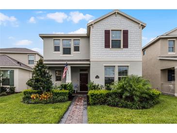 Two-story house with gray siding, brown shutters, and a landscaped front yard at 17066 Water Spring Blvd, Winter Garden, FL 34787