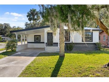 Updated home with modern facade, carport, and well-manicured lawn at 2471 E 20Th St, Sanford, FL 32771